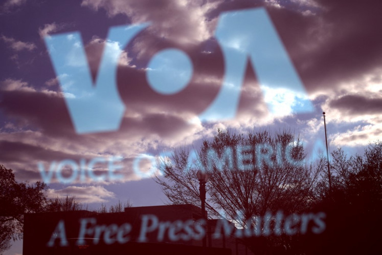 The Voice of America (VOA) sign is seen on the glass window of a bus stop on March 17, 2025 in Washington, DC.